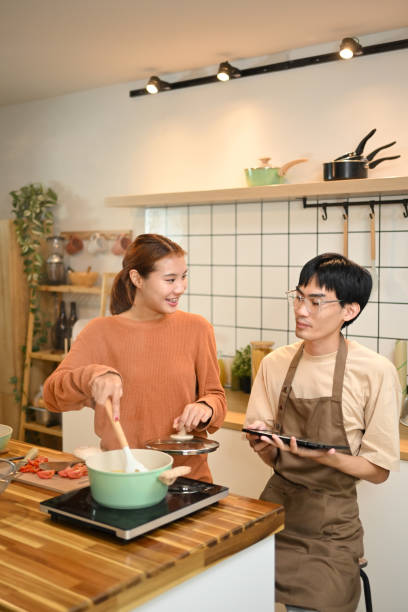 istock An affectionate young couple making a lunch together in domestic kitchen 2174602023