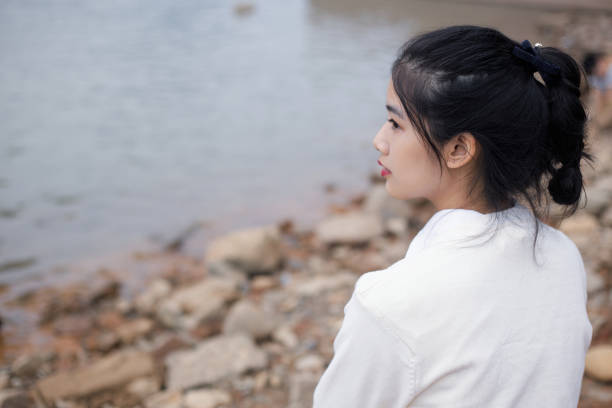 istock Asian girl relaxing by the seaside 2174603823