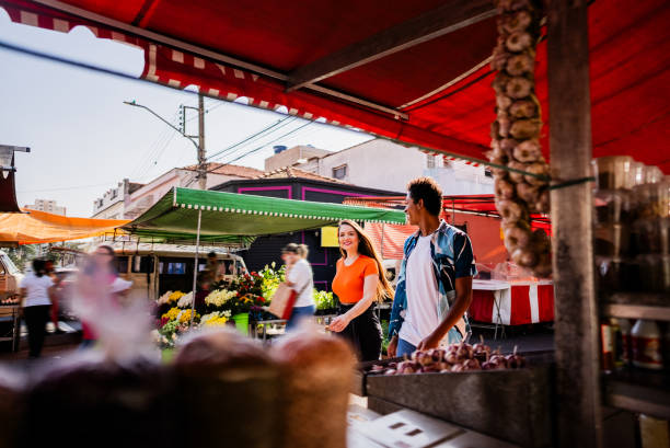 Young friends talking while walking in a street market