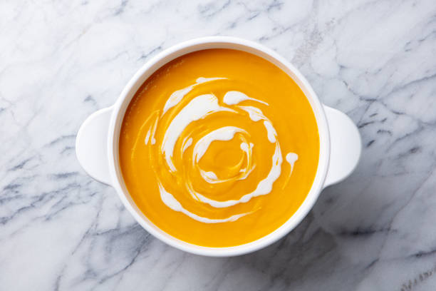 istock Pumpkin soup in white pot, saucepan, bowl. Grey background. Top view. Close up. 2174607232