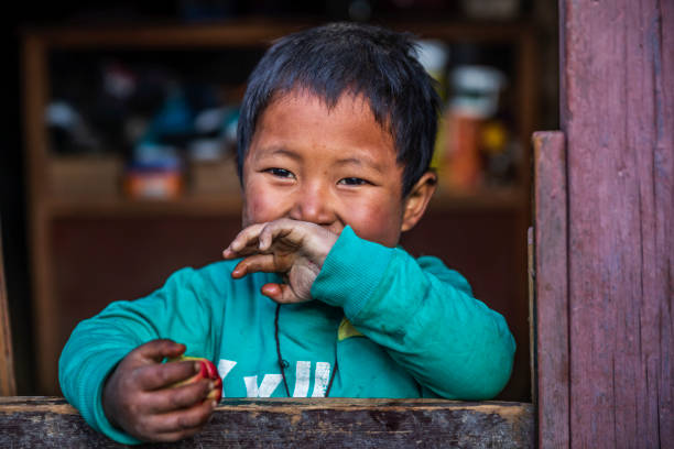 Tibetan little boy sitting inside his father's shop, local village in Upper Mustang. Mustang region is the former Kingdom of Lo and now part of Nepal,  in the north-central part of that country, bordering the People's Republic of China on the Tibetan plateau between the Nepalese provinces of Dolpo and Manang.