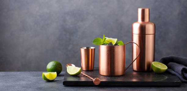 istock Moscow mule cocktail in copper mug, shaker with fresh mint and lime. Grey background. Copy space. 2174607810