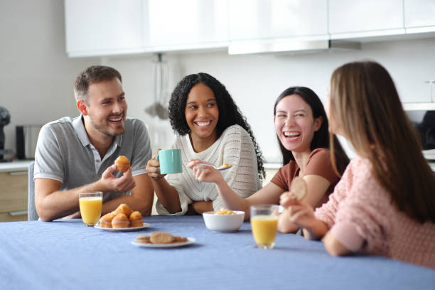 istock Happy interracial roommates and friends talking at breakfast 2174608438