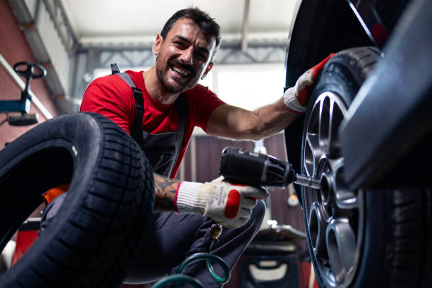 istock Tire workshop. Car mechanic removing wheels from vehicle. 2174611049