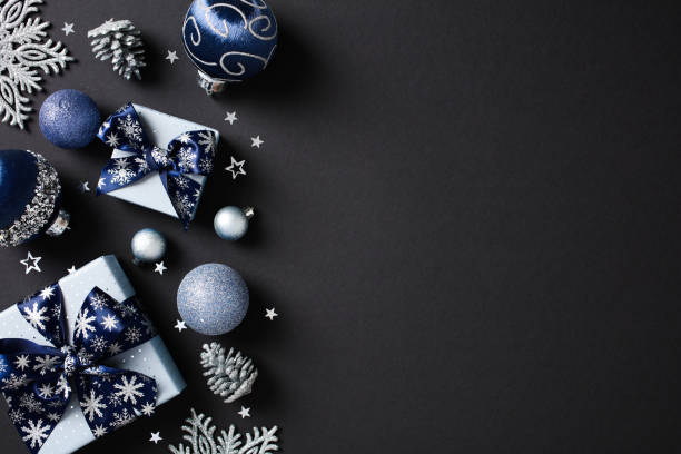 istock Festive holiday decor with blue and silver accents on a dark backdrop. Includes baubles, gift boxes, pine cones, and glittering decorations. Perfect for Christmas and holiday-themed content 2174611428