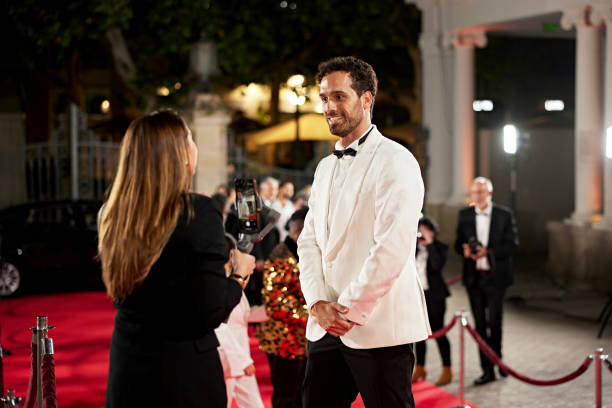 istock Young vlogger interviewing celebrity on red carpet 2174614743