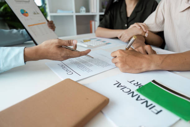 istock Financial Planning and Saving Concept with People Discussing and Signing Documents at a Desk 2174614842