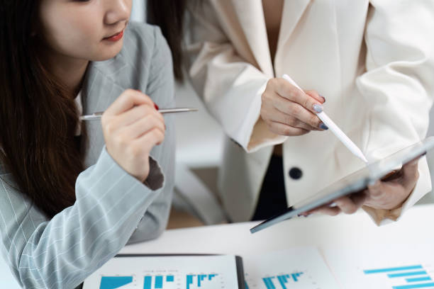istock Professional Business Meeting with Colleagues Analyzing Financial Data on Tablet and Documents 2174615450