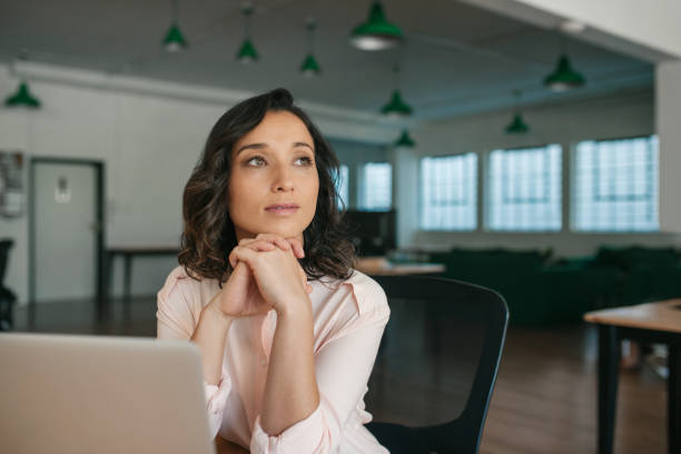 istock Young businesswoman sitting at her office desk thinking about work 2174623508