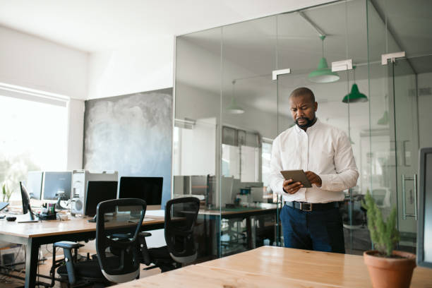 istock African American businessman standing in an office using a tablet 2174624802