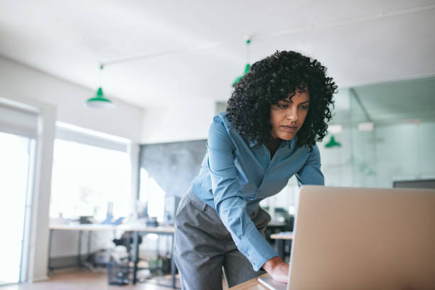 istock Focused businesswoman leaning over her office desk using a laptop 2174625289
