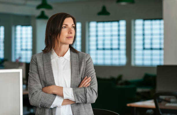istock Businesswoman deep in thought while standing by her office desk 2174627239