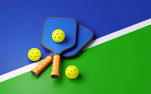 istock Pickleball Balls And Racket Pair On Blue Court 2174628193