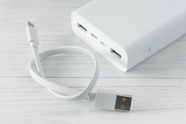 istock Powerbank for charging mobile devices with cable on white table 2174628395