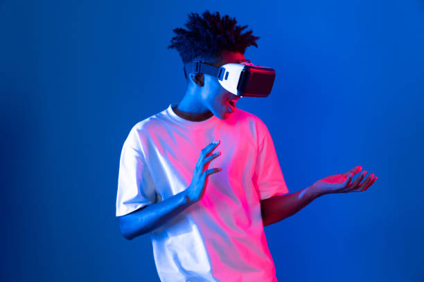 istock Surprised African looking VR holding object hologram neon wall. Contrivance. 2174629413