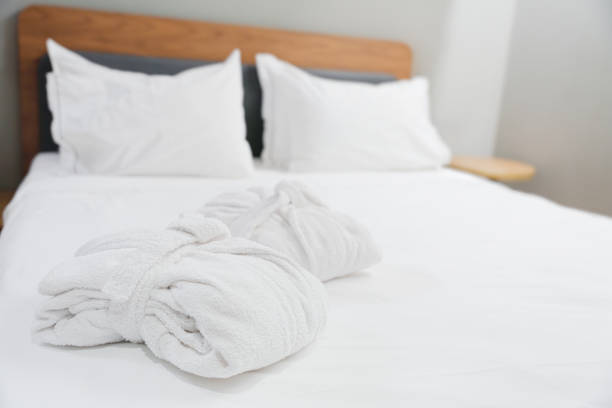 istock Folded Terry Robes On Bed With White Linens 2174631702