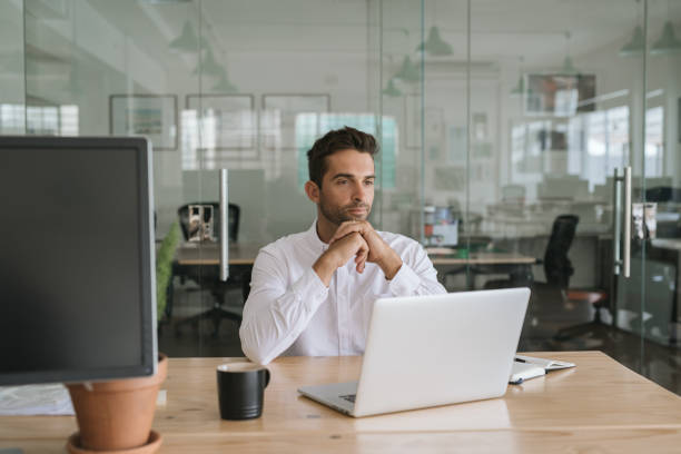 istock Young businessman sitting in an office looking deep in thought 2174637105