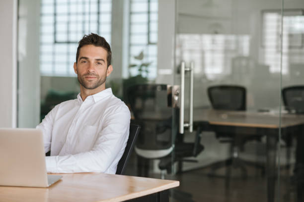 istock Confident young businessman sitting at his office desk 2174638798