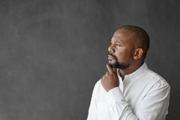 istock African American businessman standing by a chalkboard deep in thought 2174639257