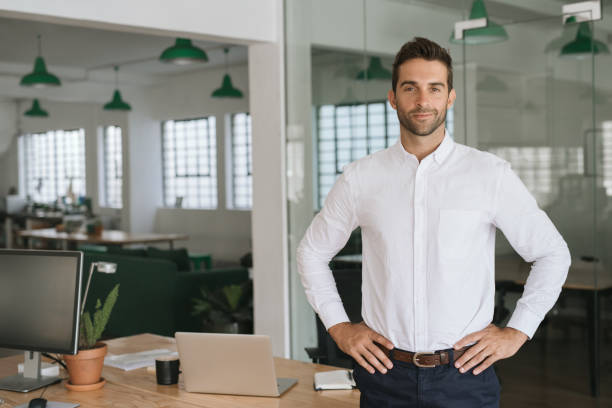 istock Confident businessman smiling while standing in a large modern office 2174640548