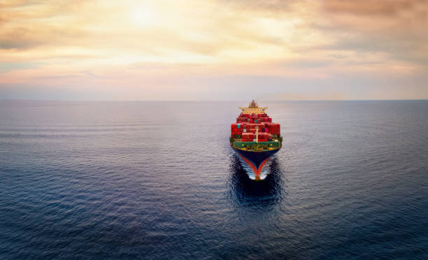 istock Aerial front view of a cargo container carrier ship sailing over the ocean during sunset time 2174642961