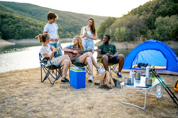 istock Friends having fun while camping by the lake 2174643752
