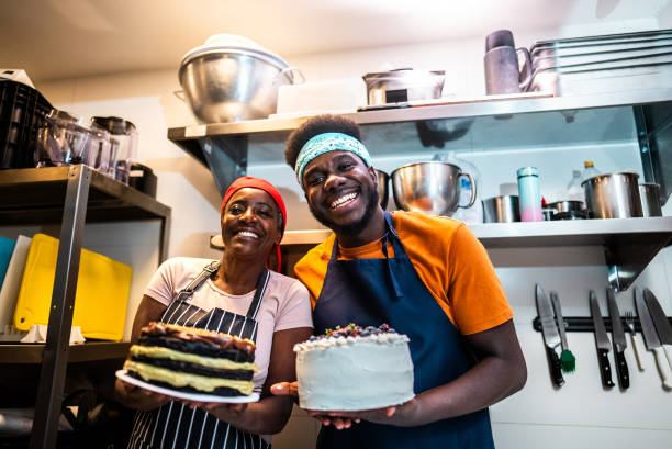 istock Portrait of colleagues holding a cake at bakery kitchen 2174643997