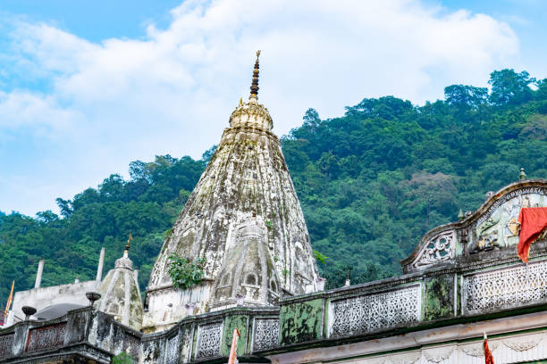 istock Ancient hindu temple towering over lush green forest in india 2174644710