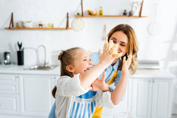 istock A mother and daughter share joyful baking moments in a bright, laughter-filled kitchen 2174646444