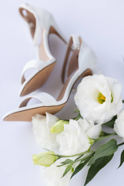 istock White wedding sandals with white flowers. Selective focus. 2174649775