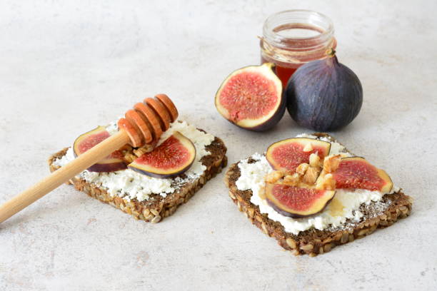 istock toasts with fig, curd cheese, honey and walnut on gray background 2174650776