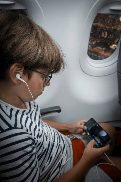 istock Boy playing video games at airplane 2174655886