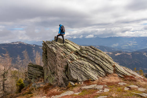 istock Ladinger Spitz - Man with a hiking backpack on a massive rock on summit Gertrusk on the way near Ladinger Spitz, Saualpe 2174656888