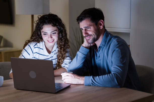 istock Young couple browsing internet on laptop at home in the evening 2174659722