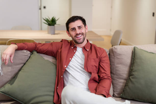 istock Man smiling relaxing on comfortable sofa at home 2174660038