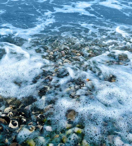 Sea surf and foam over beach pebbles on Prestatyn beach