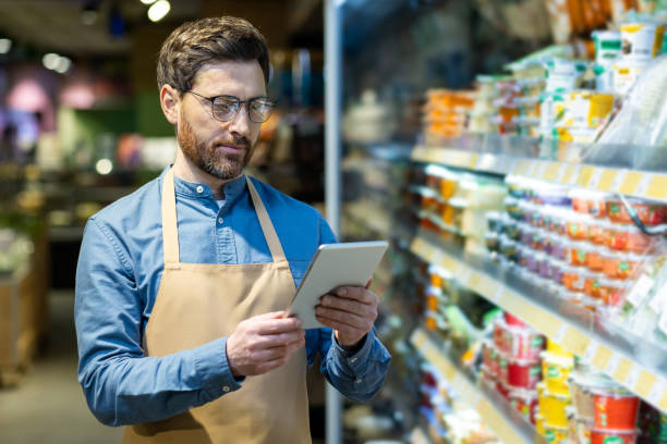 istock Grocery store manager using digital tablet for product inventory and stock analysis in supermarket aisle with dairy products 2174665748