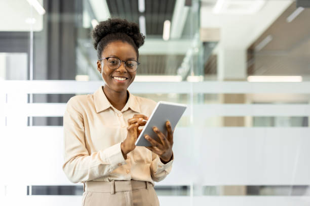 istock Confident African American businesswoman using tablet in modern office setting, showcasing digital workplace and professional technology use 2174667504