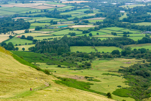 istock Distant hikers ascending a trail on a grass covered mountain ridge 2174669268