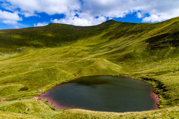 istock Beautiful small lake below towering, green mountains 2174669304