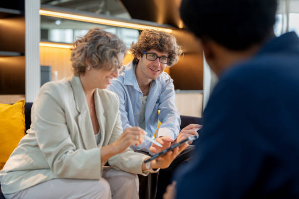 A team of digital marketers holds a strategy meeting in a co working space office, discussing how to improve targeting and segmentation using Customer Relationship Management solutions.