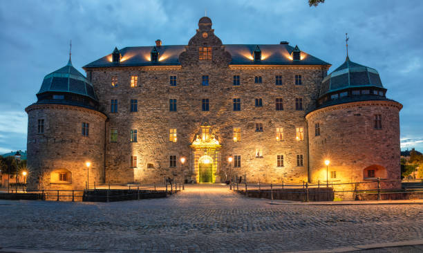 Orebro, Sweden- August 4, 2024:  Castle fortification at Svartan river by night . Tourist atraction and history entusiast destination.  Copy space