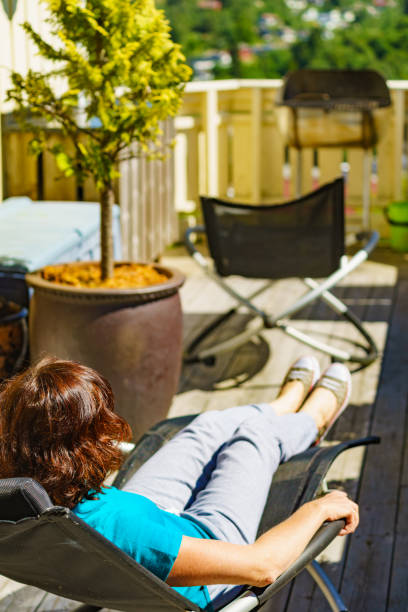 istock Woman relaxing in chair on veranda. 2174672633