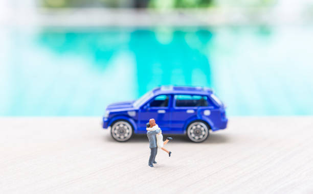 istock Miniature couple with blue car over blurred swimming pool background 2174672695