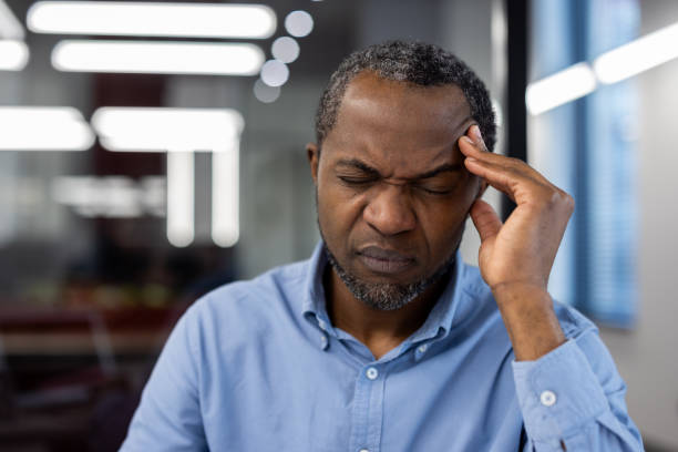 istock Stressed businessman with headache holding head in office environment, dealing with work pressure 2174673353