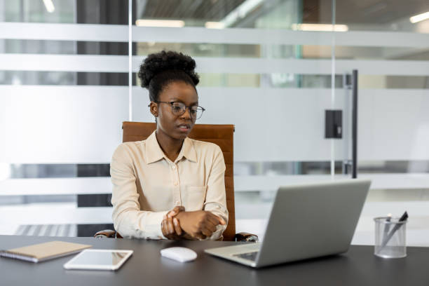 istock African American businesswoman experiencing wrist pain in modern office setting during work on laptop 2174674830