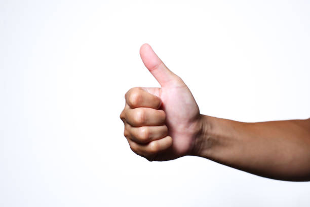 Man gives the thumbs-up sign outdoors.