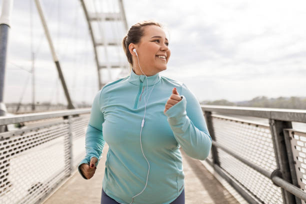 istock Overweight Young Woman Running Across Bridge 2174681346