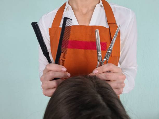 Hair stylist preparing for a haircut with various tools in a salon setting