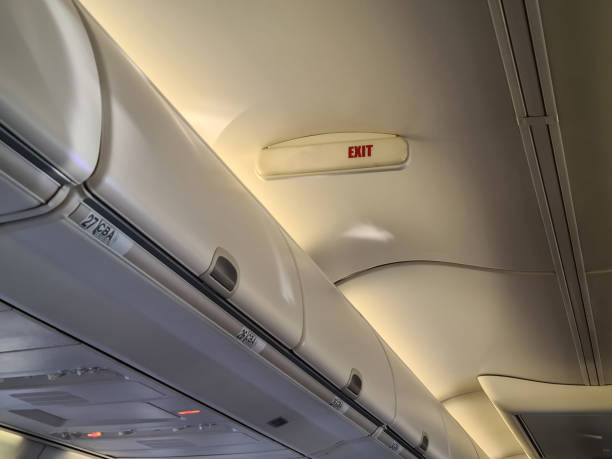 istock Interior view of an airplane cabin highlighting the exit signage and overhead storage during a flight 2174681972